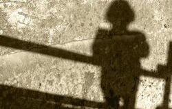 Schatten einer Person vor einem Geländer stehend